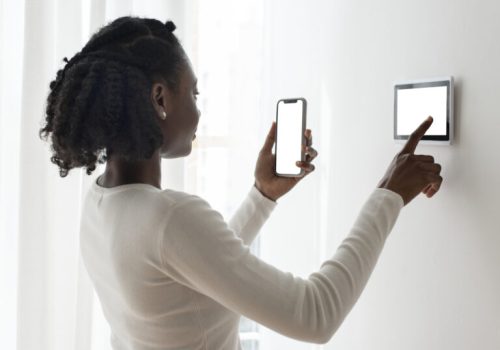 Woman pressing on smart home automation panel monitor